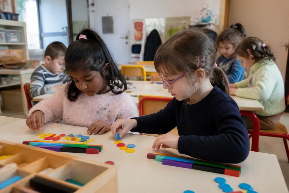 Enfants apprenant algorithme en maternelle avec des jetons colorés en classe active